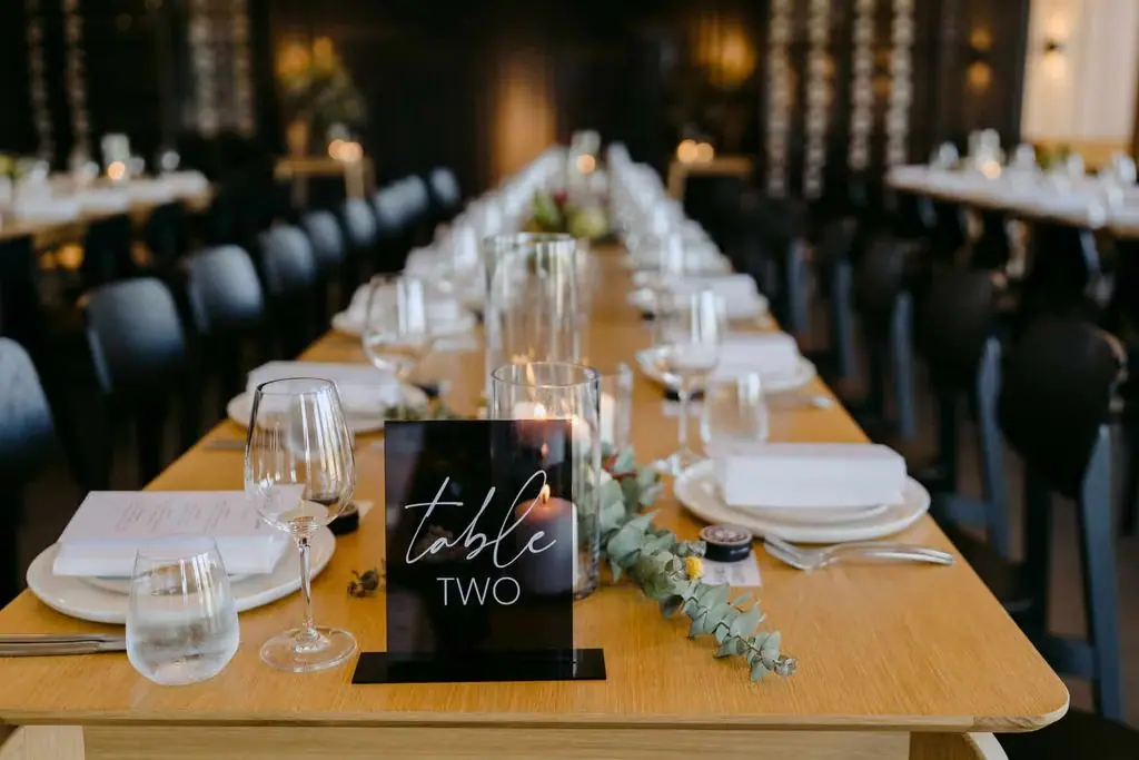 Reception table set with plates, glassware and flowers