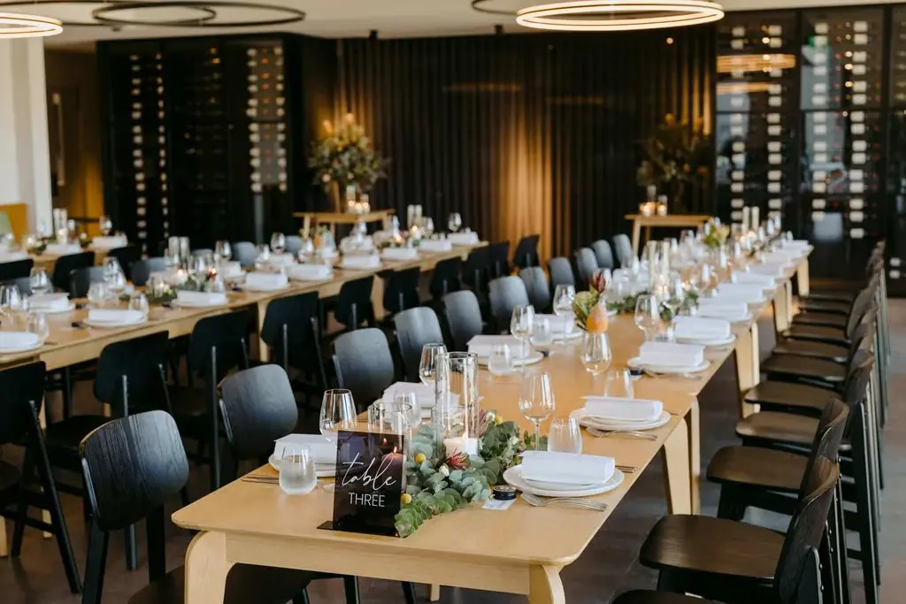 Long wedding reception tables beneath circular ceiling lights