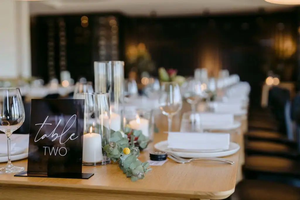 Wedding table number and candlelit floral centrepiece