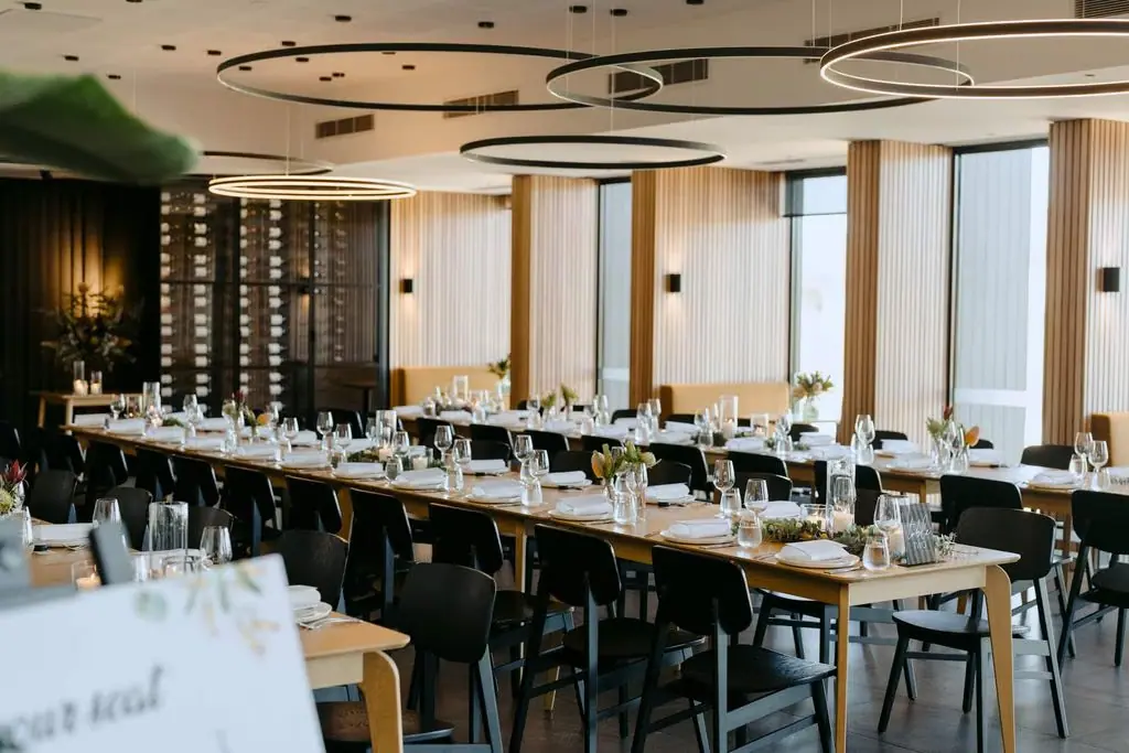 Wedding reception table set beside tall windows