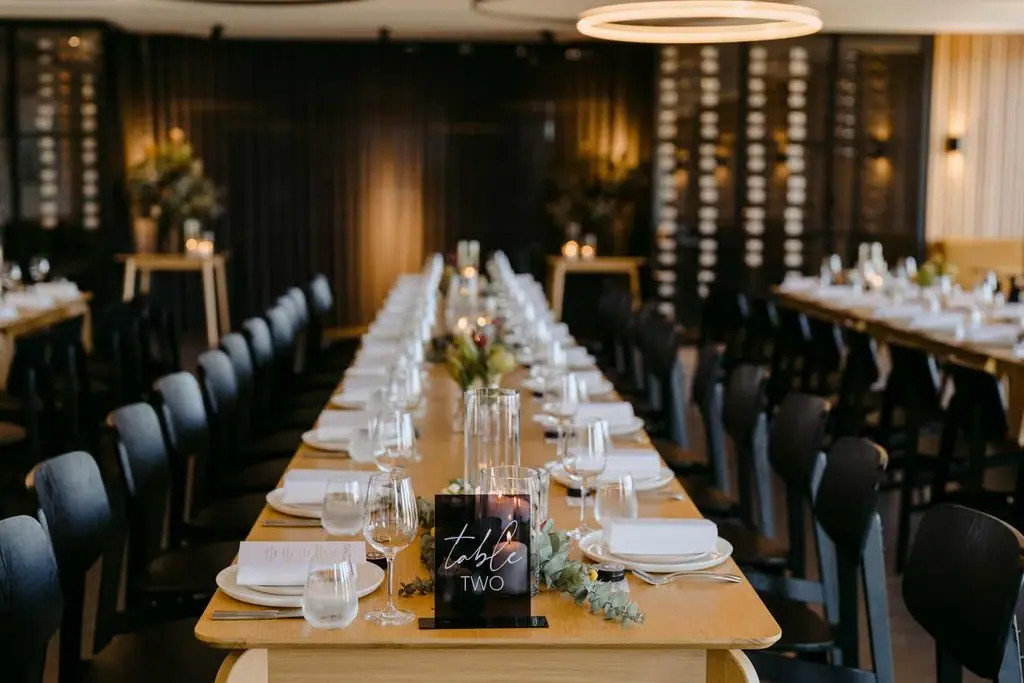 Long reception table decorated with flowers and candles