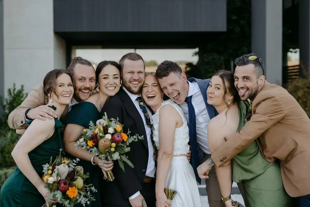 Wedding party leaning together for a group portrait