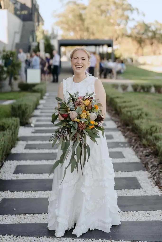 Bride holding her bouquet on the venue steps