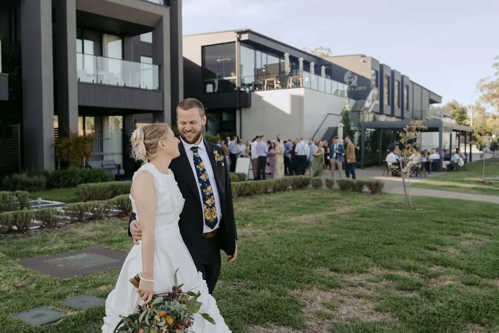 Couple walking together with the venue behind them