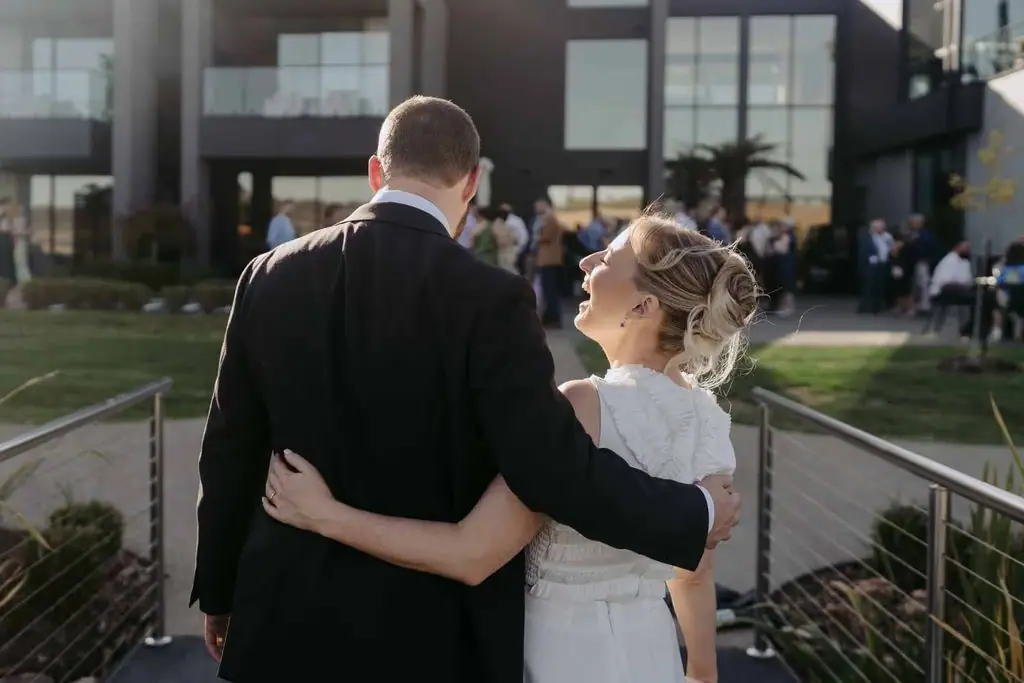 Couple embracing with their backs to the camera outside the venue