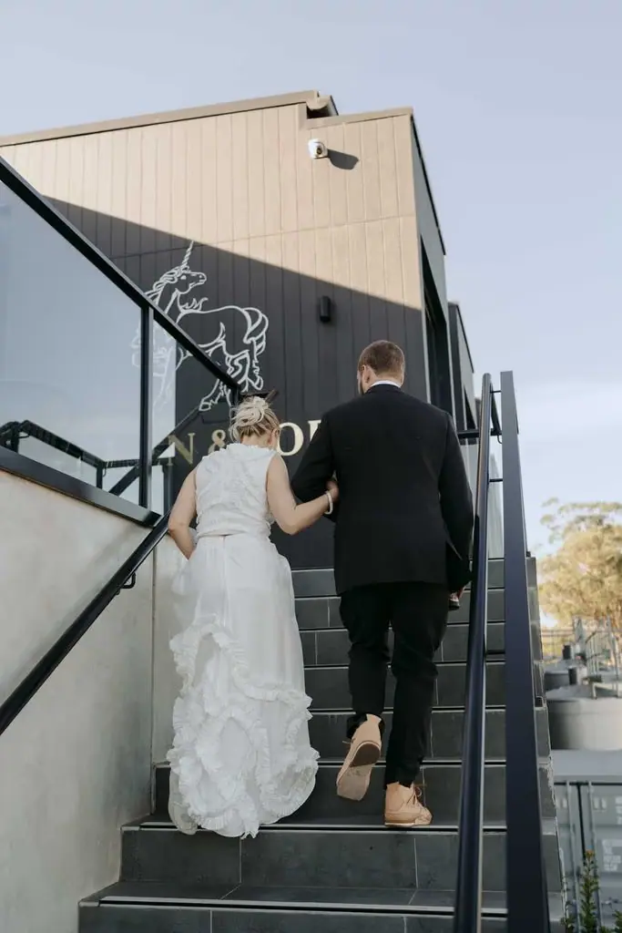 Couple climbing exterior steps at the wedding venue