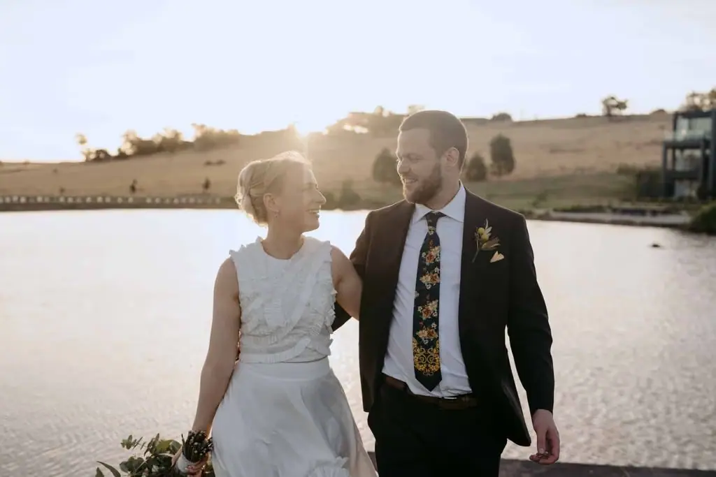 Couple walking hand in hand beside the water