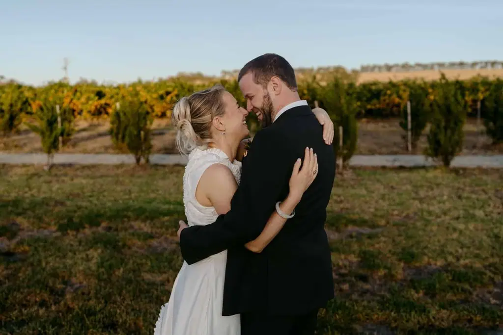 Groom kissing the bride's forehead in the vineyard