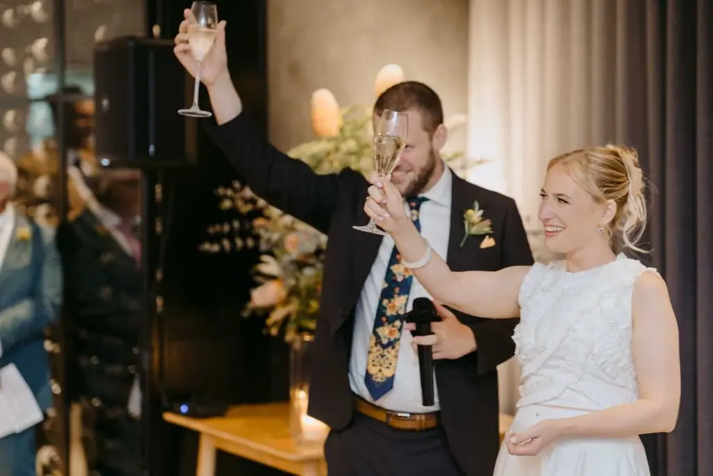 Couple raising their arms and cheering at the reception