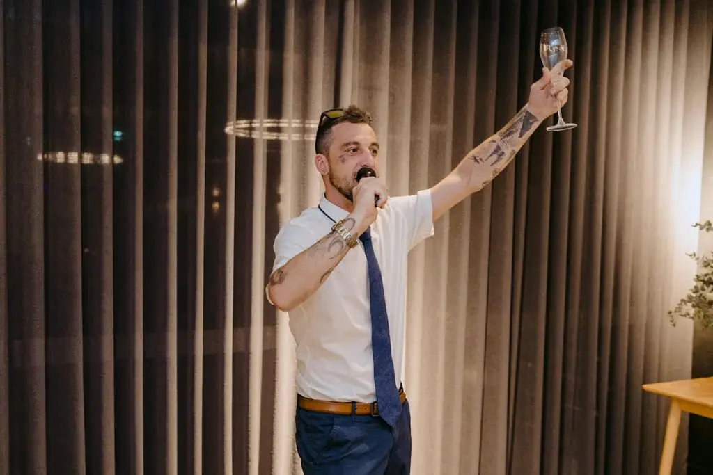 Guest in suspenders raising an arm during his speech