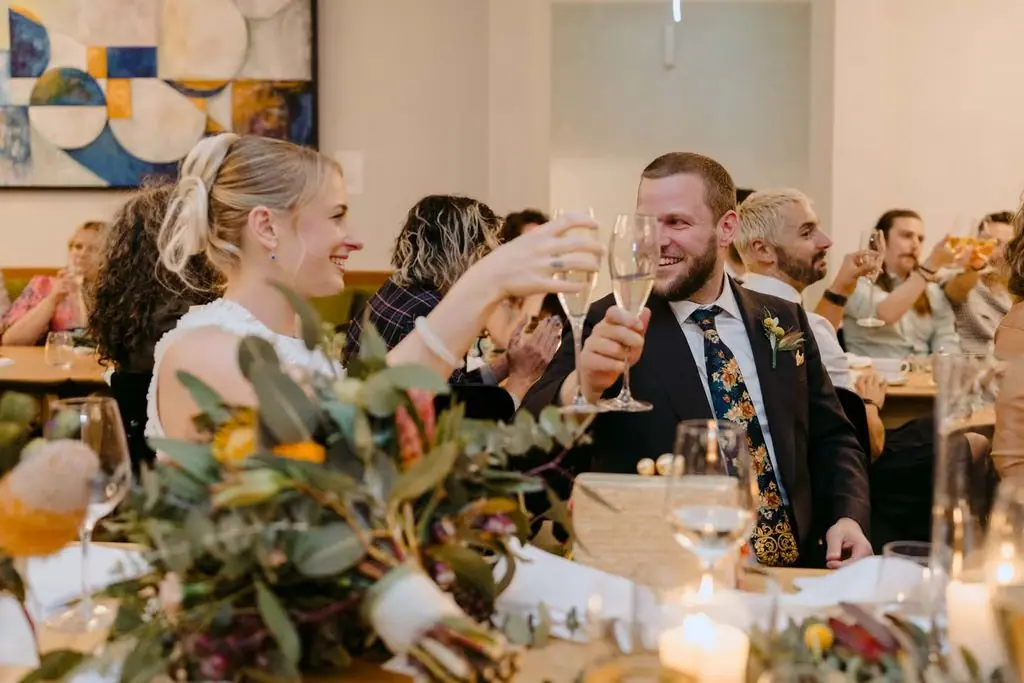 Guest raising a glass to the seated groom