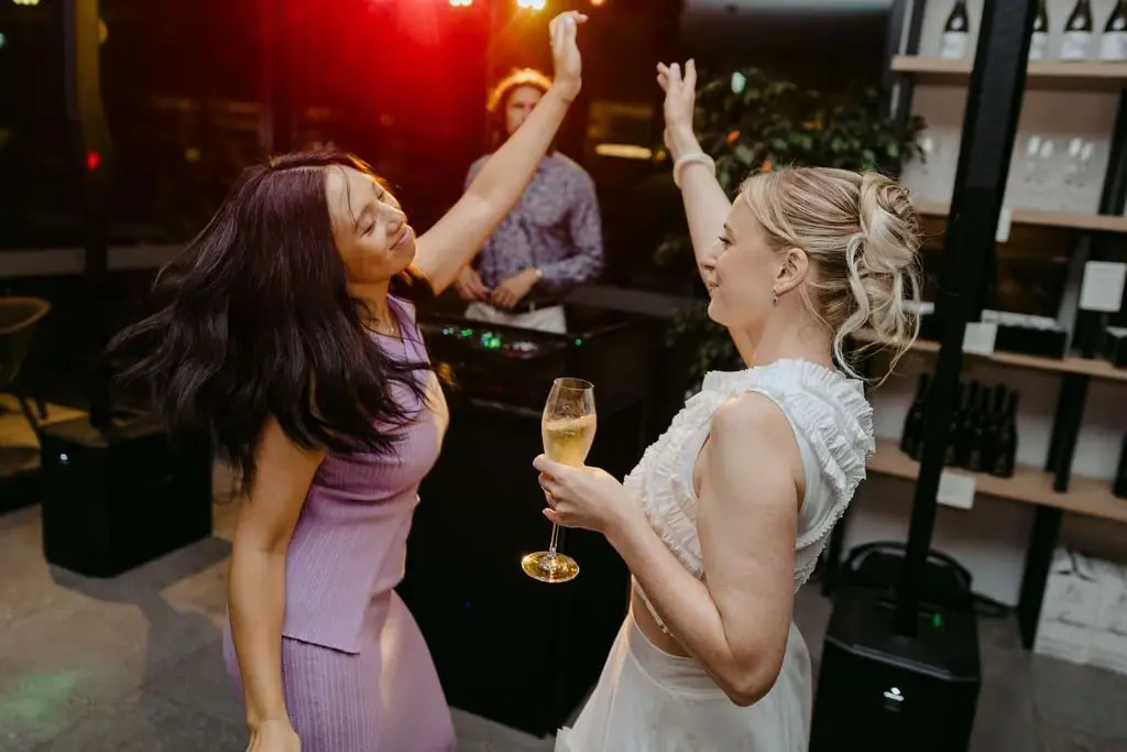 Bride dancing with a guest indoors