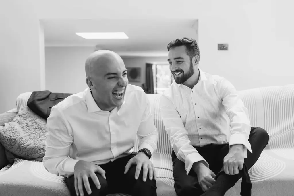 Black-and-white photograph of two men laughing while getting ready