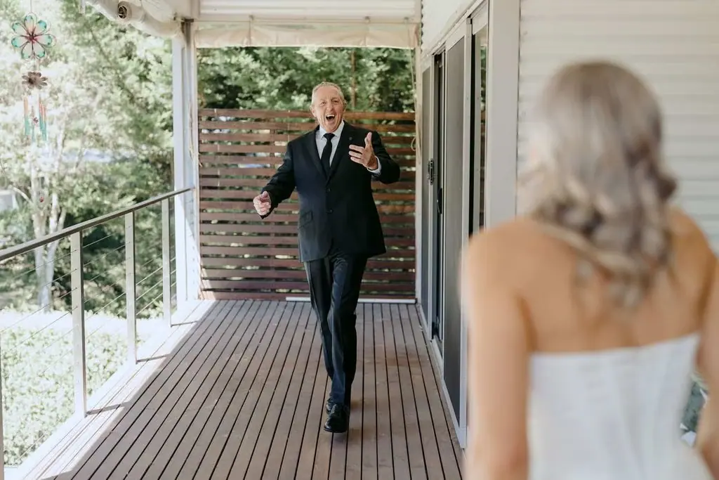 Older guest greeting the bride on a covered veranda