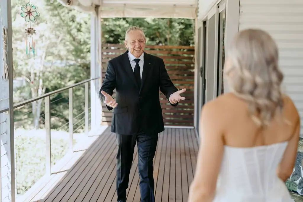 Older guest smiling at the bride on the veranda