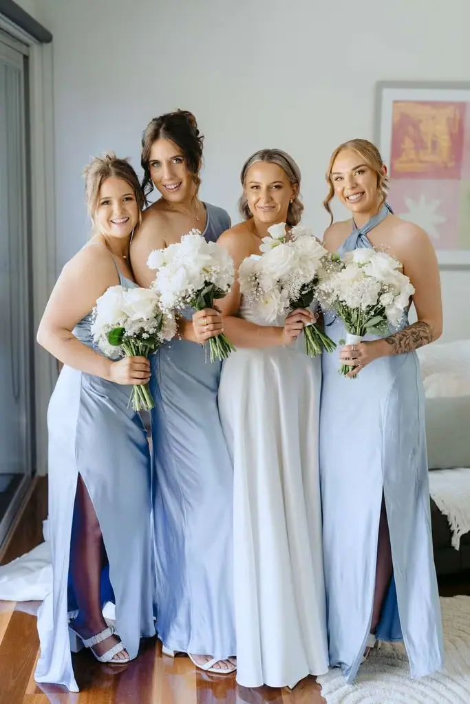 Bride and bridesmaids holding bouquets indoors