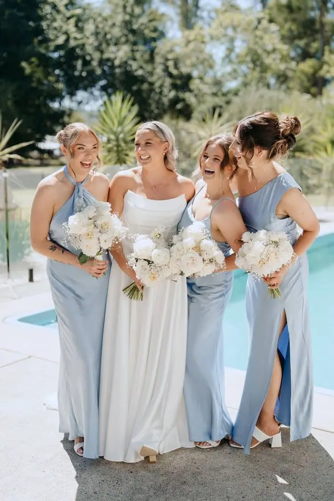 Bride and bridesmaids standing together beside the swimming pool