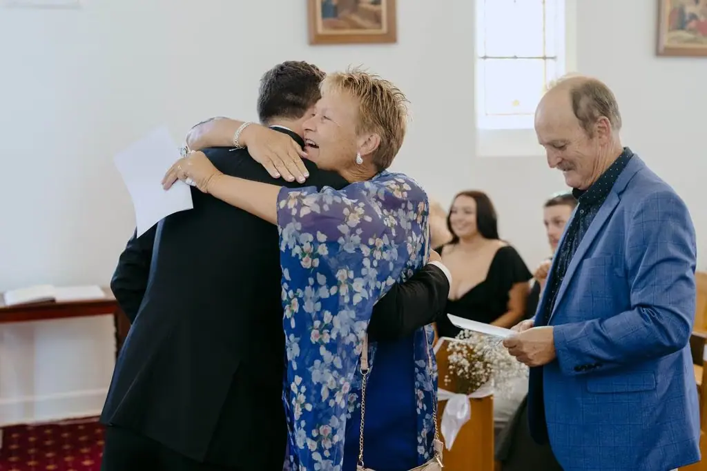 Guest embracing the groom inside the church