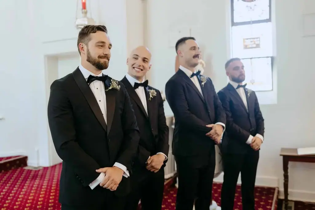Groom and groomsmen waiting at the front of the church