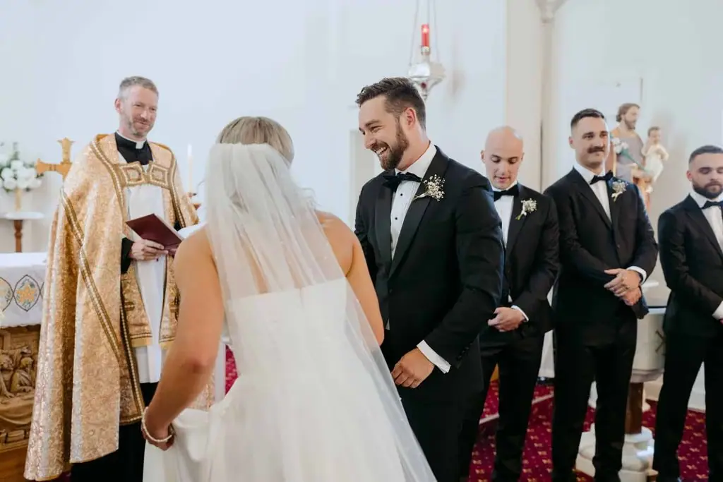 Couple standing together before the priest during their wedding ceremony