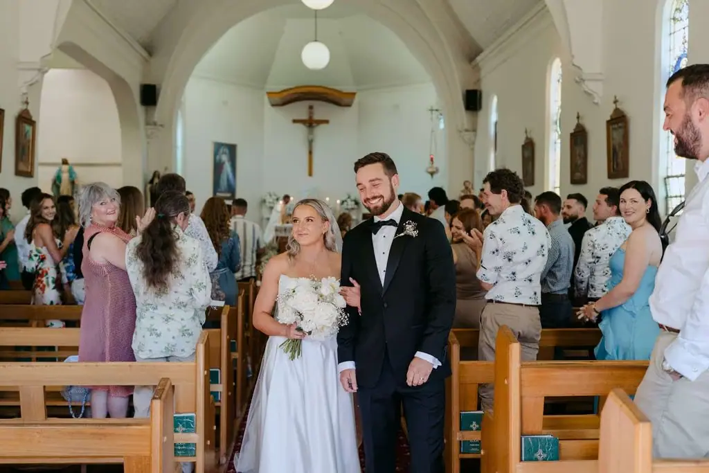 Newlyweds walking back down the church aisle