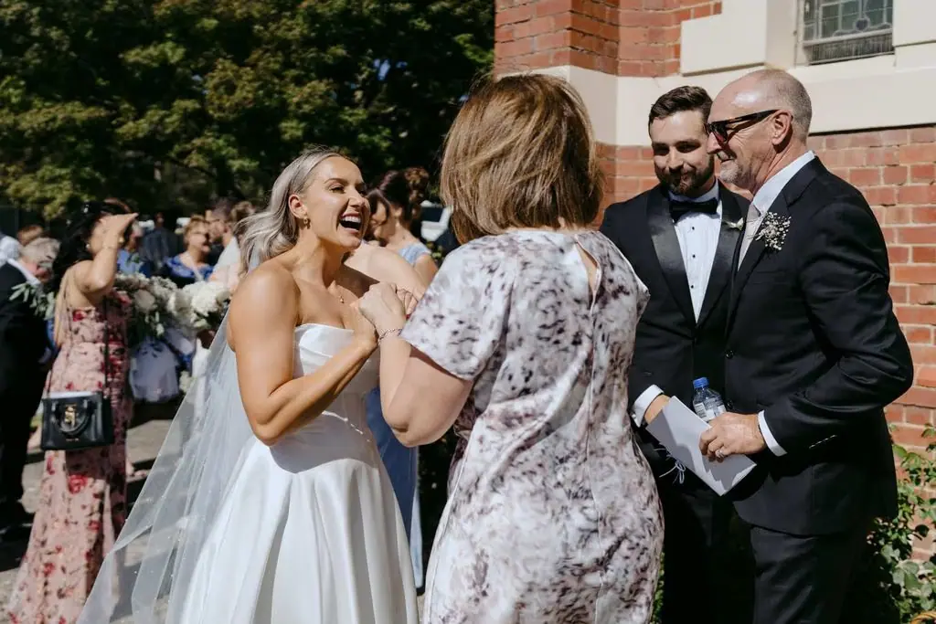 Bride and groom chatting with guests outside the church