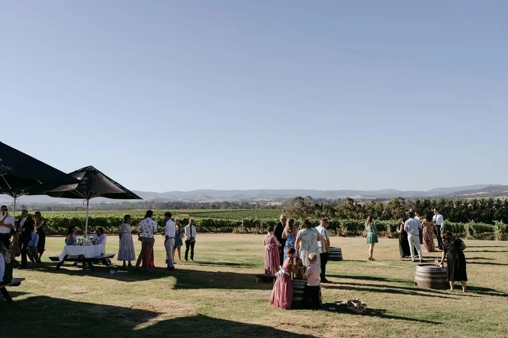 Wide view of wedding guests gathering on a lawn