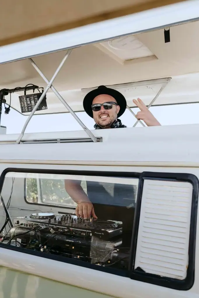 Guest leaning out of a white vehicle with sound equipment inside