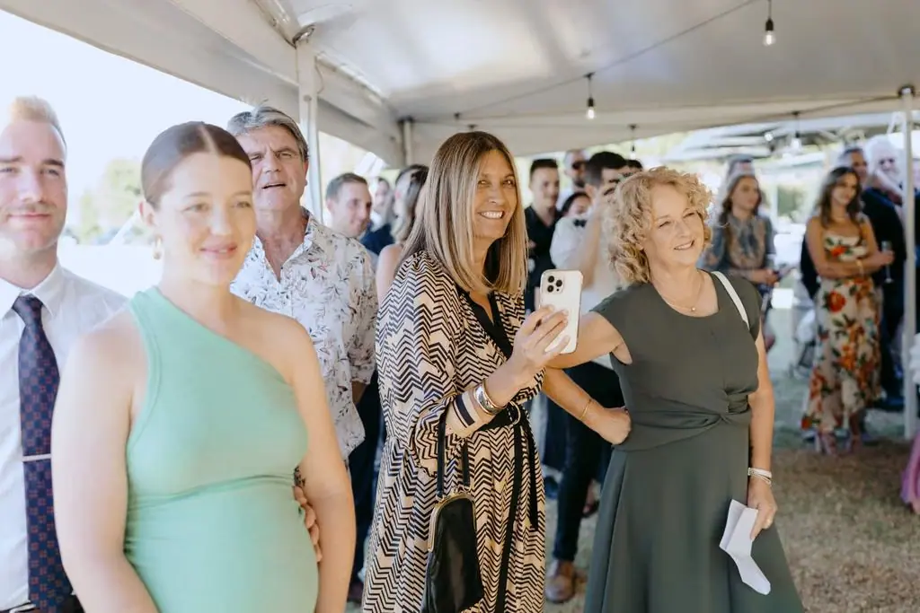Women smiling together beneath the marquee