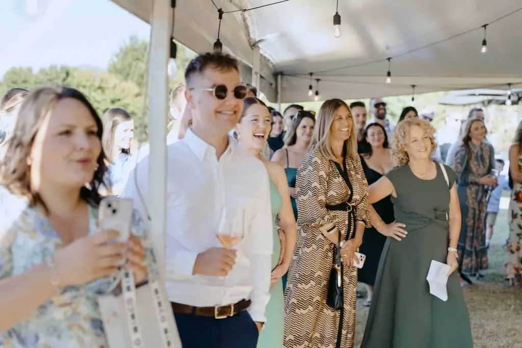 Guests smiling while watching a reception speech