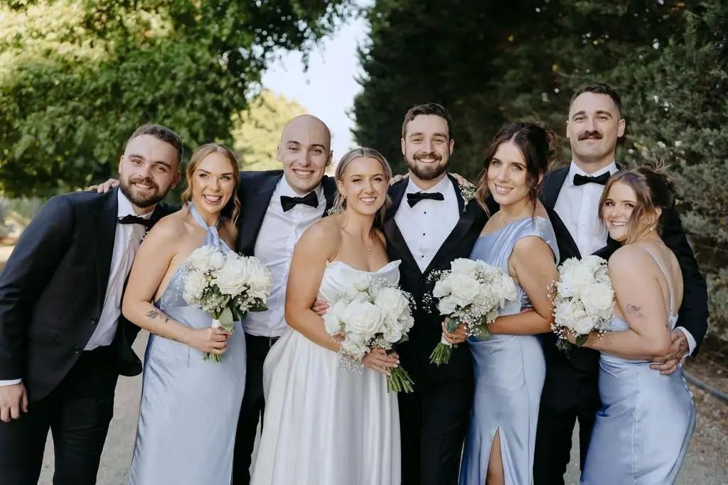 Wedding party leaning together and smiling for a group portrait