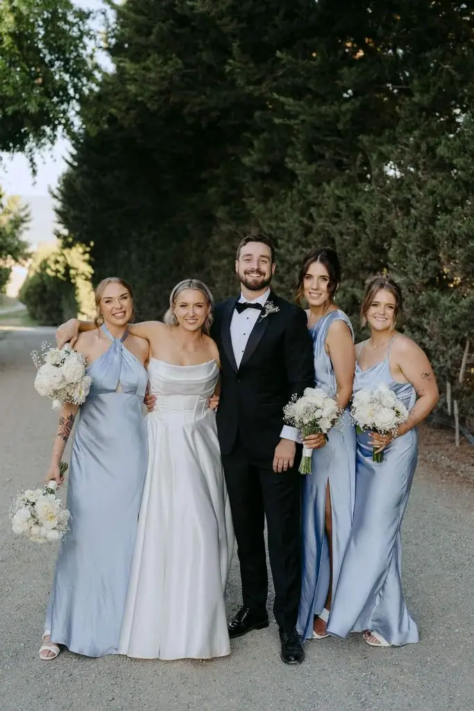 Bride and three attendants posing on a garden path