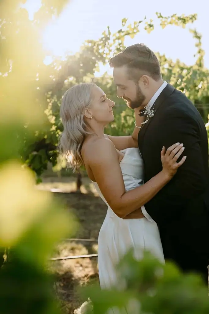 Couple embracing in warm sunlight beneath a tree
