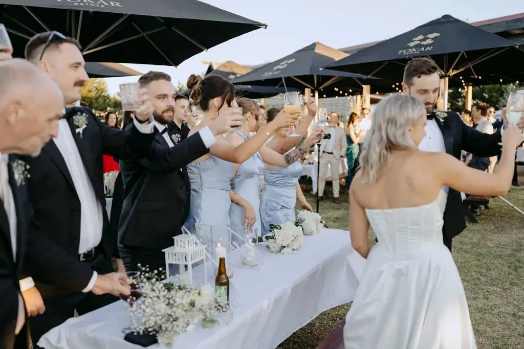 Guests raising glasses towards the bride in a toast
