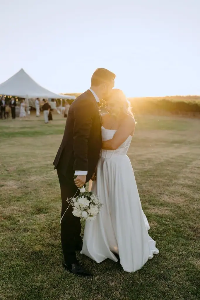 Couple holding hands and touching foreheads in evening sunlight