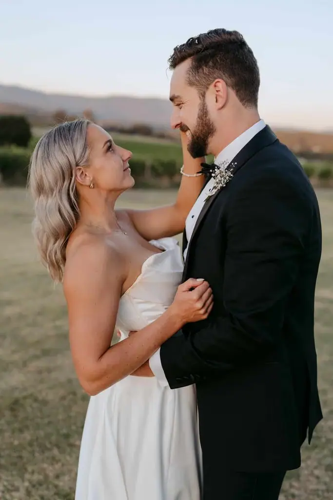 Couple laughing together in a field at dusk