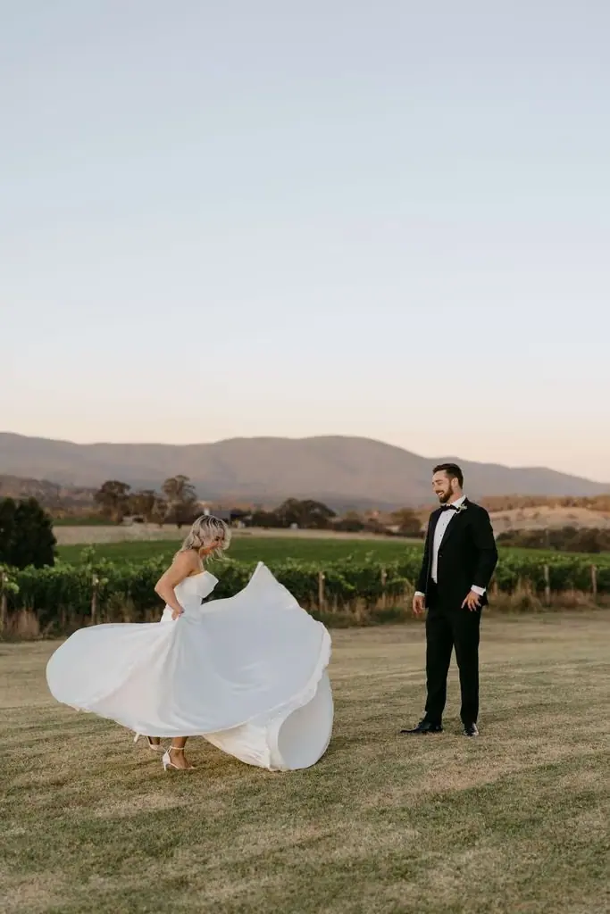 Bride spinning her dress while the groom holds her hand