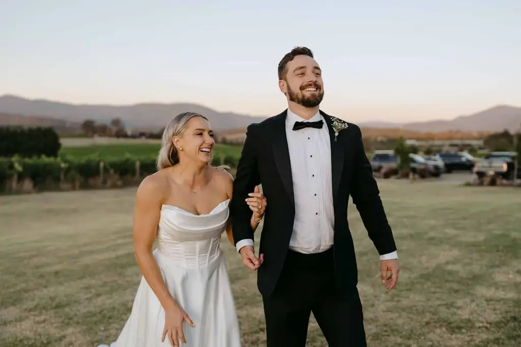 Couple laughing together as they walk across the field