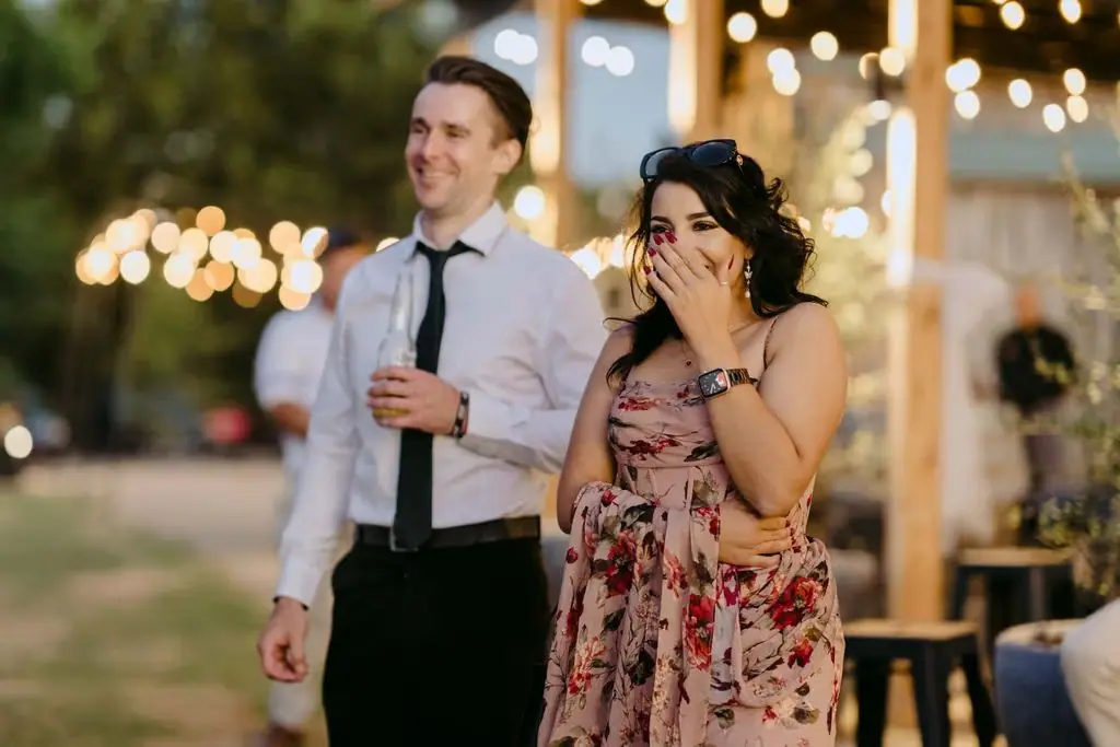 Two guests giving a speech beneath warm string lights