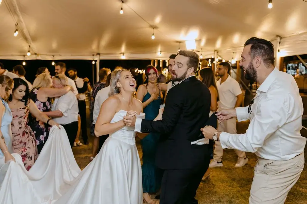 Bride dancing beside the groom and a guest