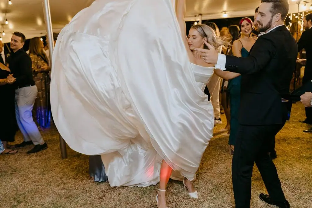 Bride's skirt swirling as the groom spins her on the dance floor