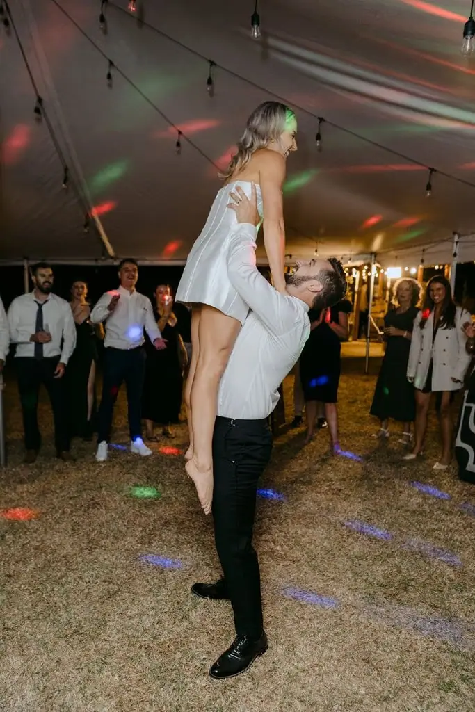 Groom carrying the bride on his shoulders at the reception