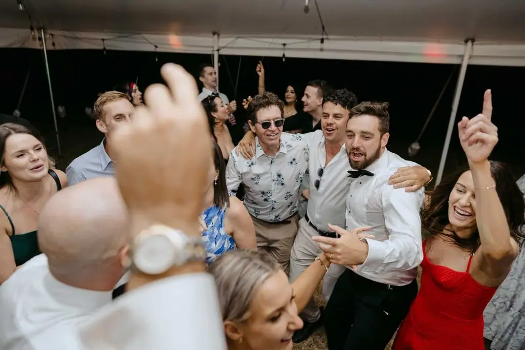 Guests dancing together beneath the marquee
