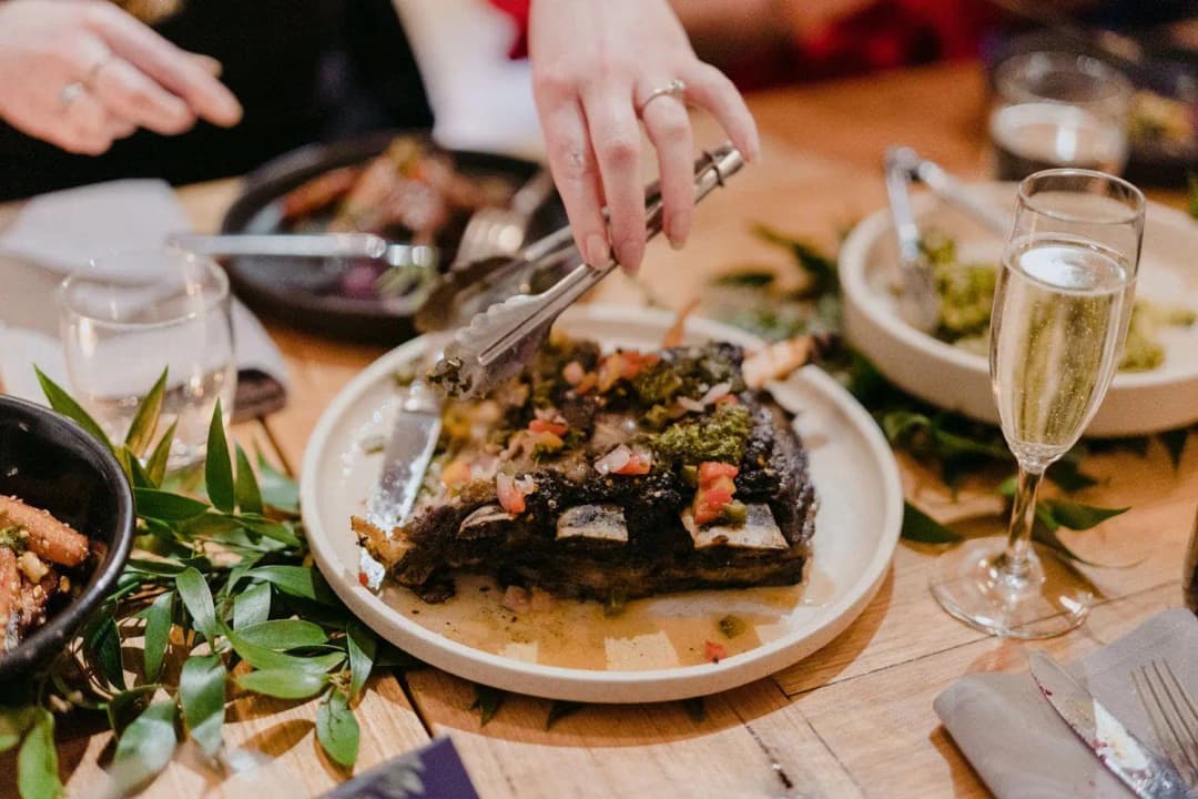 Guests serving themselves from a shared platter at a reception table.