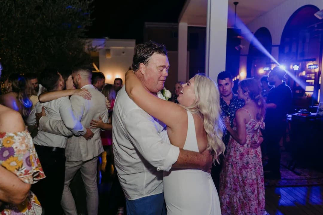 Bride dancing with a man as other guests dance around them