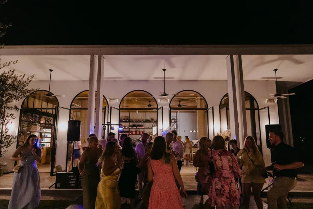 Wedding guests dancing outside the reception building after dark