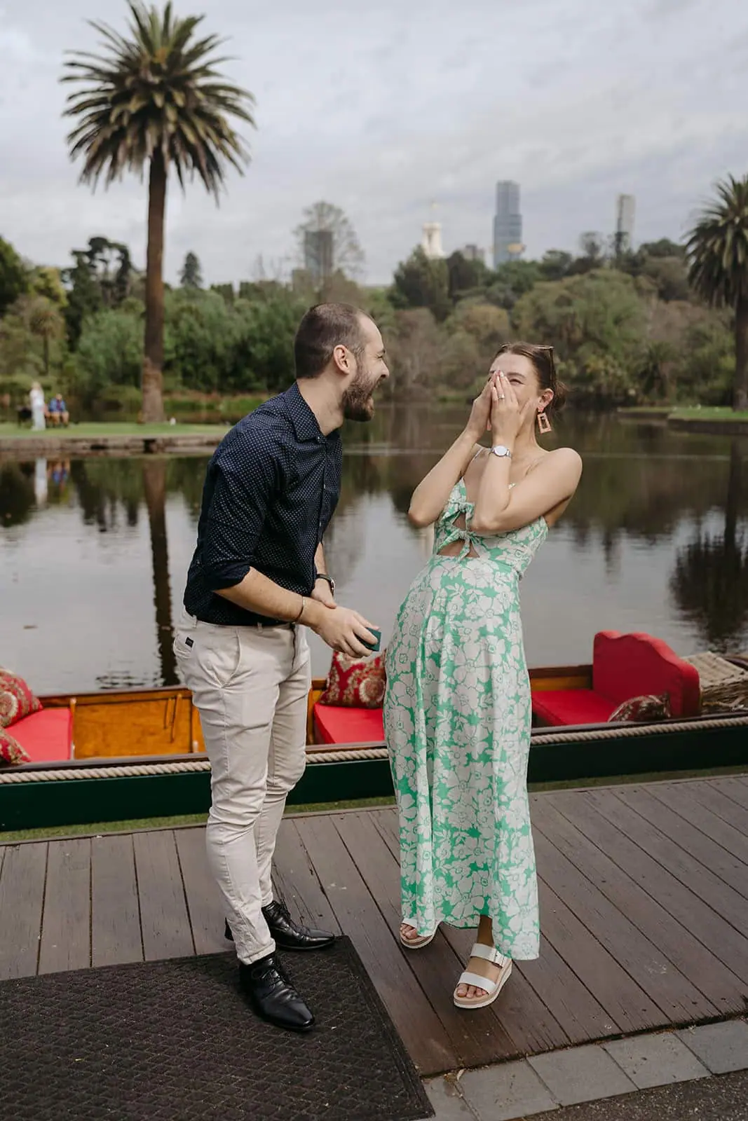 Couple smiling beside a lakeside boat after the man stands up.